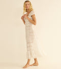 Woman wearing a white lace dress on a beige background