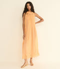 Woman wearing a peach-colored dress against a plain background
